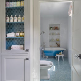 Bathroom with Build in Shelves and Blue Claw Foot Tub