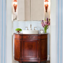 Kenilworth Bathroom. Antique mahogany vanity with tole sconces & blue striped walls.