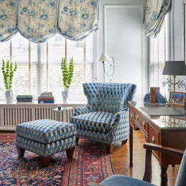 Kenilworth Living Room. Blue drapes and upholstery with antique writing desk, classic oriental rug & paneled walls.