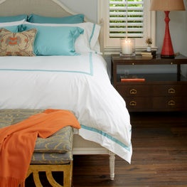 Coastal master bedroom with turquoise and orange accents