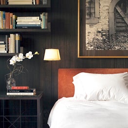 Bedroom with dark-stained anigre wood walls