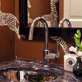 Upper East Side powder room with animal print wallpaper and dark marble sink