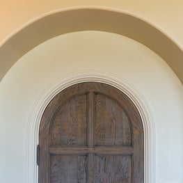 Arched Natural Wood Door inset into Plaster Arch