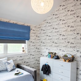Hamptons kids room with vaulted ceiling, animal print wallpaper and blue tones
