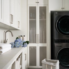 Featuring two washers, dryers, and drying racks along with plenty of storage and folding space, this laundry room can keep up with demand all week.