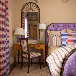 A fun, colorful but practical cottage bedroom with exposed wood beams