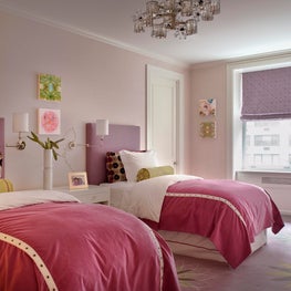 Pink and purple girls bedroom in NYC apartment, upholstered headboards.