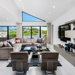 LAKEFRONT CONTEMPORARY VILLA, modern den, modern living room, glass door, triangle window, floating shelves, lucite arm chairs