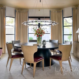 A luminous gold ceiling, rich drapery with blue details, and a custom circular table set the stage for intimate gatherings in this dining room.