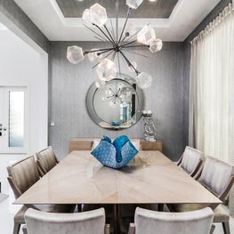 SLEEK CONTEMPORARY METALLIC RESIDENCE metalic walls, sunburst chandelier, large round mirror, taupe dining chairs, teal art glass