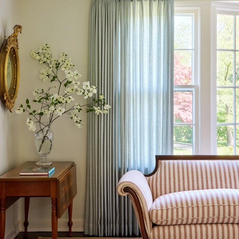 Flanagan Interiors, cover: Living Room with antique loveseat and soft blue sheer curtains
