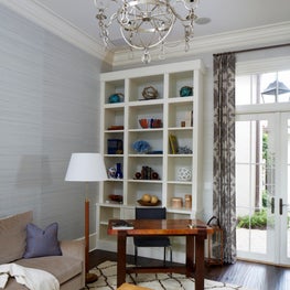 Home office with Moroccan rug, copper desk, leather ottoman