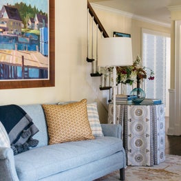 Glenview Foyer. Soft blue sofa with a skirted table, yellow and blue accents & a light blue oriental rug.