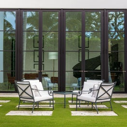 A courtyard garden with a view to the music room through large steel doors