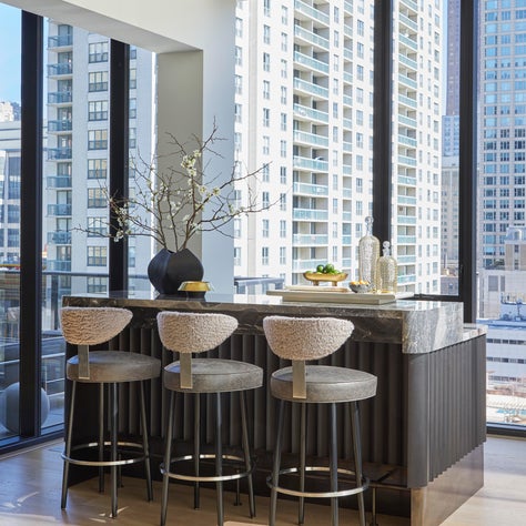 A custom bar inspired by Joseph Dirand combines fluted wedge wood, Orobico marble and antique brass base.