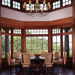 The wood framed windows bring the lush outdoors into the inviting dining area.