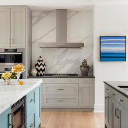 Sleek Kitchen with Island and Bar Area, Shaker Cabinetry, Marble Backsplash