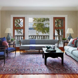 Historic Lake House Great Room. Black spindle chairs with navy upholstery, blue and red accents & a classic Persian rug.