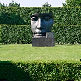 Layers of trimmed hedges frame sculpture and contrast with its sensuous forms.