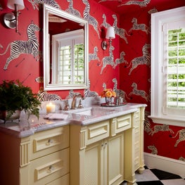 A vibrant Zebra scalamandre wallpaper print is this bathroom's backdrop.