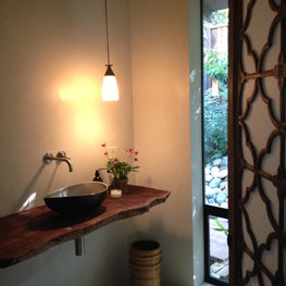 Menlo Park, CA - Guest Bathroom: all plaster walls and floors, hand carved doors, California walnut slab, artisan light