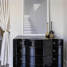 Portfolio: Modern serpentine chest with glossy, black finish and gold detailing.