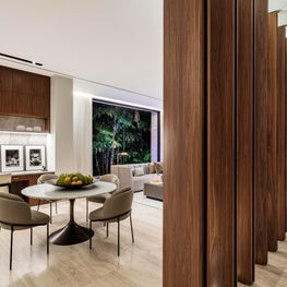Vertical walnut beams elegantly swiveling to separate kitchen and formal areas