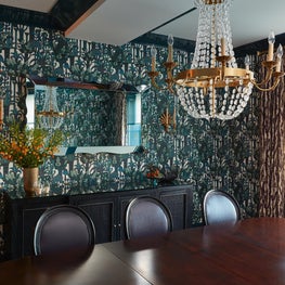Dramatic dining room with chandelier and hermes wallpaper