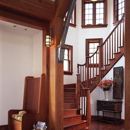 The warm wood tones accent the windows and staircase in the magnificent New England home.