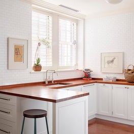 White glass subway tile full-wall backsplash & mesquite butcher block counters