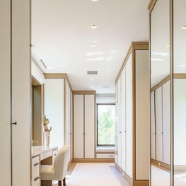 Oak cabinetry with paper backed linen panels in a beach house dressing room