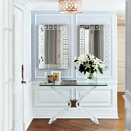 Sophisticated entryway with Moldings, Mirrors, and Chevron Floors.