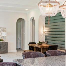 This open kitchen & dining room features modern accent chairs & bench seating. 