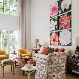A patterned upholstered armchair faces floor-to-ceiling paned windows.
