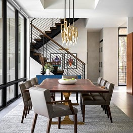 With a live-edge top and brass base, this custom dining table serves as the defining element of the dining room.