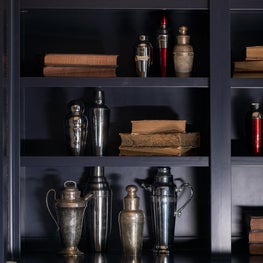 Collection of antique cocktail shakers adorn built-in cabinets