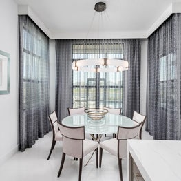 SLEEK CONTEMPORARY METALLIC RESIDENCE breakfast knook, kitchenette, modern round glass dinning table, long gray curtain sheers, white dining chairs