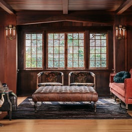 Craftsman library with wing chair, burnt orange sofa, leather ottoman, florals