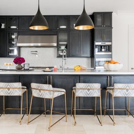 Portfolio: High contrast kitchen with dark stained cabinetry, white counters, and gold accents