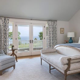 Master bedroom with navy blue embroidered Christopher Farr drapes and linens