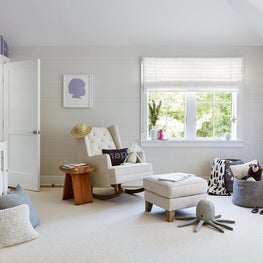 Bright nursery complete with whimsical purple wallpaper and custom art