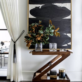 Portfolio: A bar cart from Z Gallerie made of dark wood.