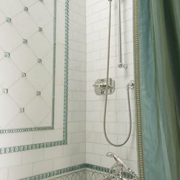 The tub/shower is lined with White Thassos and Ming green mosaic tiles combined with iridescent glass insets.