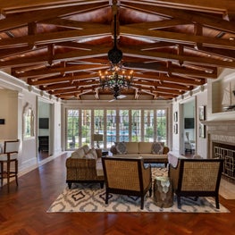 A pool house great room in Palm Beach with an operable glass wall