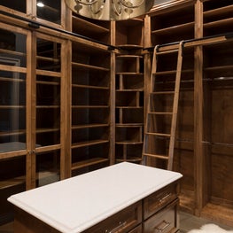 Custom Closet in warm stain finish along with center island and sliding ladder 