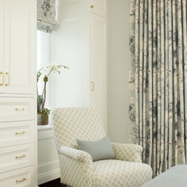 Park Avenue master bedroom with white built ins, blue floral window treatments