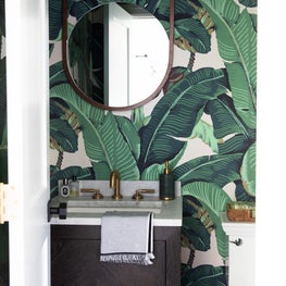 Fun Hamptons powder room with banana leaf wallpaper and brass features 
