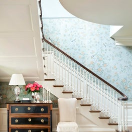 Relaxed foyer and staircase with blue floral wallpaper
