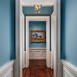 Walnut floor details and classical paneling in an enfiladed hallway procession