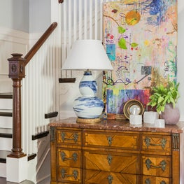 Colorful stairwell composition with statement table lamp modern art and antiques